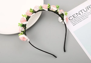 Dettaglio ravvicinato del cerchietto fatto a mano con rose rosa, bianche e bacche
