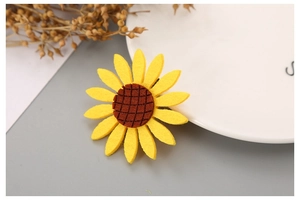 Detailed view of handmade sunflower hair clip with yellow petals and brown center