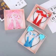 Détail de trois serre-têtes pour filles avec oreilles de chat, glands et pompons
