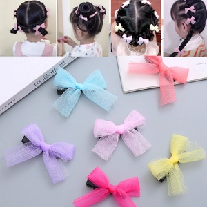 Detail of colorful mesh bow hair clips showing metal duckbill clips and sheer fabric texture