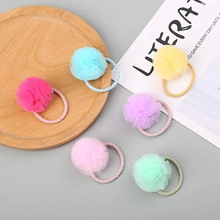 Detail of six colorful macaron mesh puff hair ties on a rustic wooden display tray
