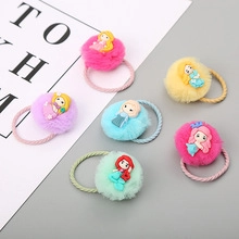 Detail of plush pompom hair ties featuring cartoon princess charms for girls