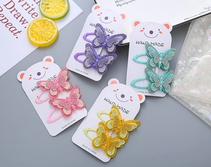 Detail showing colorful rhinestone butterfly hair clips on cute bear cards for girls