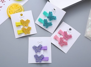 Détail de barrettes papillon en strass pour filles disponibles en quatre couleurs pastel
