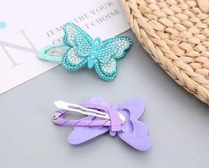 Detail of glitter butterfly hair clip with blue rhinestones and metal duckbill clip