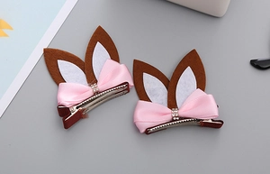 Detail of bunny ear hair clip with pink satin bow and sparkling rhinestone accents