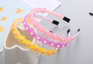 Détail de serre-têtes à fleurs pour enfants avec dents antidérapantes en jaune, violet et rose