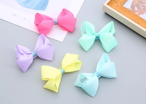 Détails de cinq barrettes à cheveux colorées en forme de nœud avec paillettes