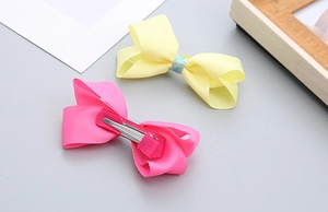 Détail de barrettes à paillettes roses et jaunes pour filles en ruban gros-grain