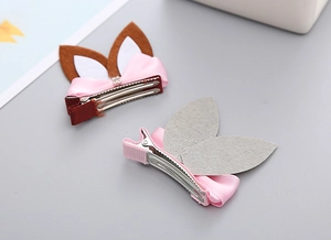 Detail view showing pair of pink bow rabbit ear hair clips with textured ribbon lining