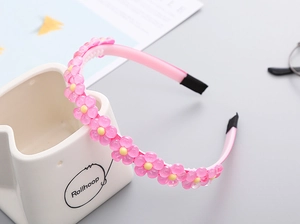 Détail du serre-tête rose à fleurs en résine avec dents antidérapantes et paillettes