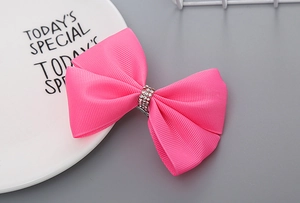 Makro-Detail einer handgemachten rosa Schleife Haarklammer mit funkelnden Strasssteinen