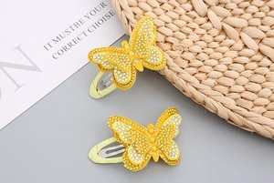Detailed close-up of yellow butterfly hair clips with sparkling rhinestones for girls