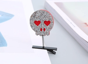 Detail view of Halloween skeleton hair clip with silver sequins and red heart eyes