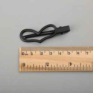 Barrette en métal noir mat en forme de cœur mesurant 5,5 cm sur fond gris