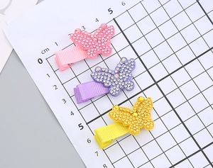 Vue détaillée de la taille de trois pinces à cheveux papillon strass sur un plateau de mesure
