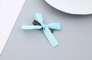 Makroaufnahme einer hellblauen Satin-Schleife Haarspange mit schwarzer Entenklammer