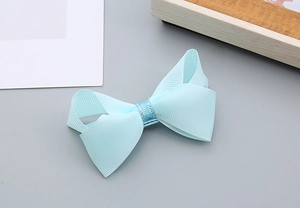 Détail du nœud papillon bleu clair en gros-grain avec paillettes argentées pour filles