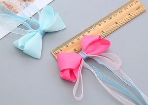 Détail de nœuds faits main rose et bleu avec échelle de mesure de longueur