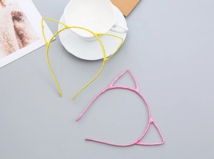 Detail of pink and yellow cat ear headbands with ribbon wrapping and handmade texture
