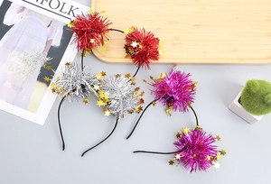 Close-up of glittery star headbands with tinsel pom poms in red, silver and purple colors