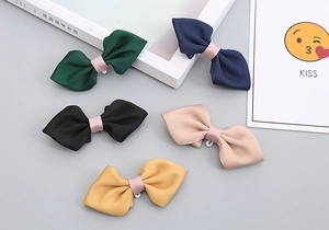 Detailed set of five fabric bow clips in solid colors with pink ribbon center wraps