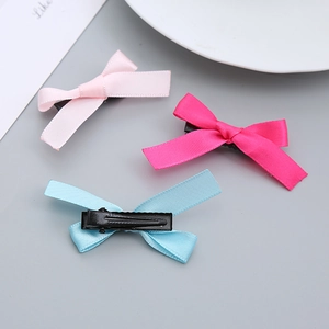 Drei süße Schleifen-Haarspangen in Pink, Rosa und Blau mit schwarzen Metallklemmen