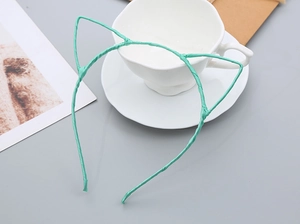 Detail showing mint green cat ear headband wrapped in textured fabric on a cup