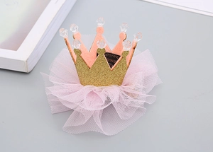 Dettaglio del fermaglio a corona in feltro rosa con glitter dorati e tulle per bambine