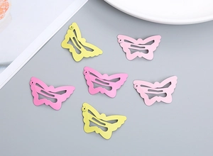Detail of hollow butterfly hair clips in matte yellow and pink pastel colors