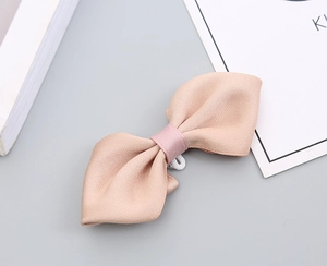 Detail of Korean style satin bow hair clip in apricot with a soft pink ribbon center