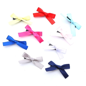 Set mit neun bunten Schleifen-Haarspangen aus Satin für Mädchen auf weißem Hintergrund