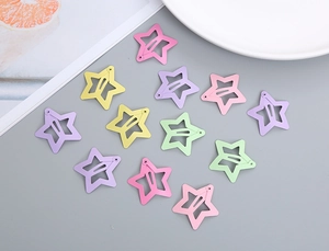Flat lay of colorful star-shaped metal hair clips in soft macaron matte finishes