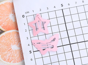 Detail view showing pink star and butterfly hair clips with scale measurements