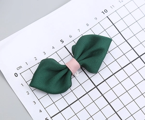 Detail showing deep green handmade bow tie size measurement of 10.5cm on white grid mat