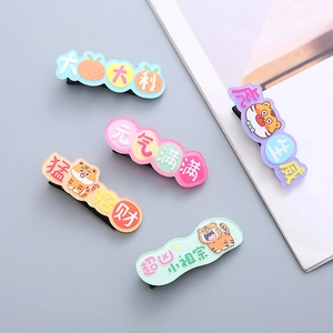 Macro detail of five colorful cartoon tiger hair clips with traditional Chinese greeting text