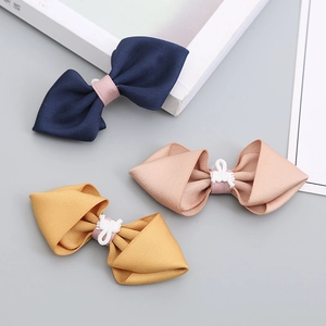 Three minimalist handmade solid color kids bow ties in navy, pink, and yellow ginger