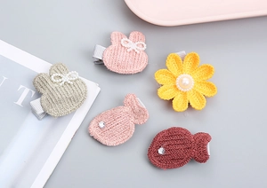Detalle de lindos clips de pelo tejidos con perlas y pedrería para niñas pequeñas