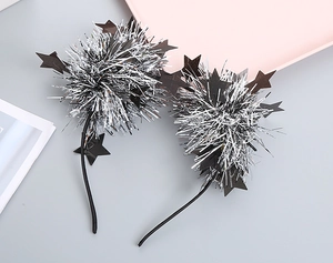 Detail of children's festive headband featuring silver tinsel pom-poms and black stars