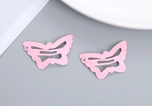 Detail view of pink butterfly-shaped hollow hair clips with matte finish for girls