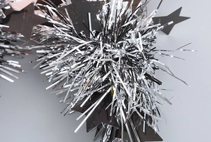 Close-up of shiny silver tinsel headband with decorative black star ornaments for parties