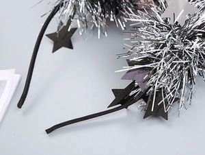 Close-up of sparkling silver tinsel stars on a black party headband for festival hair decor