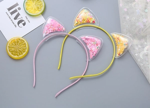 Detail of pink and yellow cat ear headbands with colorful sparkling sequins and fruit glitter