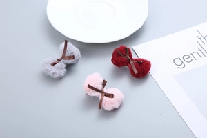 Detailed view of plush red grey and pink bow hair clips with satin ribbon accents