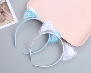 Detail of two cat ear headbands with transparent PVC ears filled with glitter star sequins