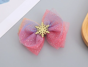 Detailed view of pink purple mesh bow hair clip with a golden snowflake decoration