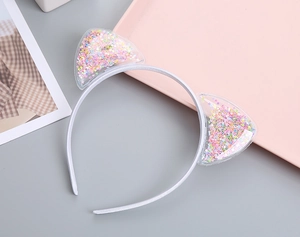 Detailed macro view of cat ears filled with colorful star sequins on a white hairband