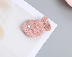 Detalle de pinza para el pelo con forma de pez de punto rosa y ojo de cristal