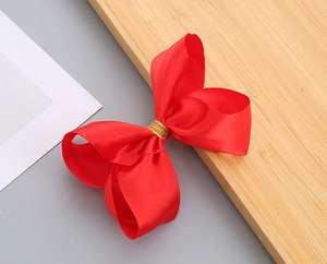 Dettaglio di una grande fascia a fiocco in raso rosso con centro in filo dorato
