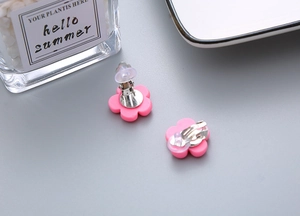 Detail view of pink flower resin clip-on earrings with soft comfort pads for girls